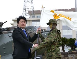 山本朋広防衛副大臣(左)が青木伸一水陸機動団長に団旗を授与した=7日、長崎県佐世保市の相浦駐屯地