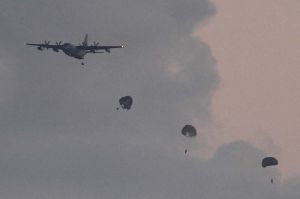 輸送機からパラシュートで降下する米兵=2日午後5時58分、津堅島沖(喜屋武綾菜撮影)