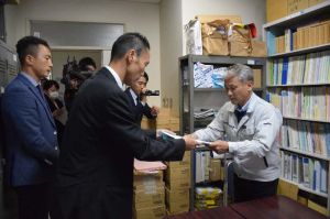 沖縄防衛局の阿野貴史次長(左)から特別採捕許可の申請書を受け取る県水産課の平安名盛正課長=24日、県庁