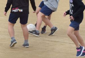 55日ぶりに使用が再開された運動場でサッカーをする児童たち=6日午前10時すぎ、宜野湾市・普天間第二小学校