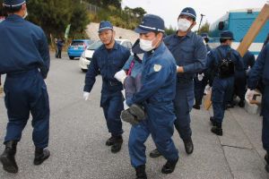 座り込んで抗議していた市民を抱え上げ、強制排除する警察官=28日正午、名護市辺野古の米軍キャンプ・シュワブゲート前