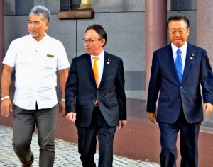 面談を終え、ホテルを後にする小沢一郎共同代表(右)と玉城デニー幹事長(中央)=24日、那覇市